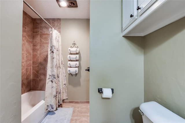 bathroom featuring a textured ceiling, toilet, and shower / bath combo with shower curtain