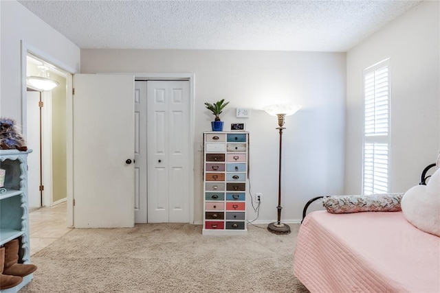 carpeted bedroom featuring a textured ceiling and a closet