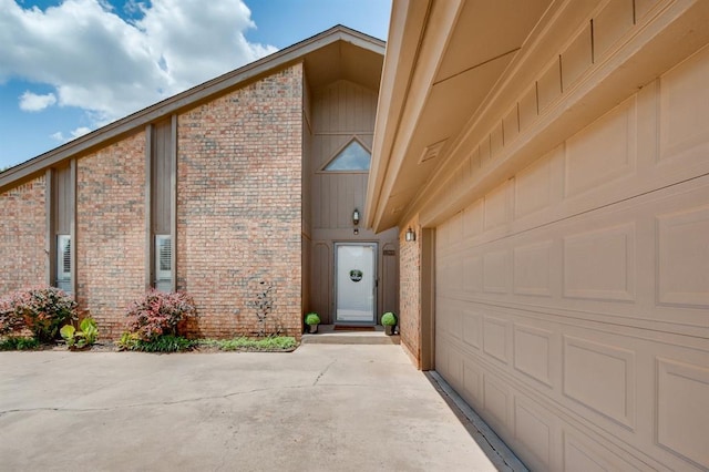 12909 Saint Christopher Dr, Oklahoma City, OK 73120 - property entrance featuring brick siding, a garage, and driveway