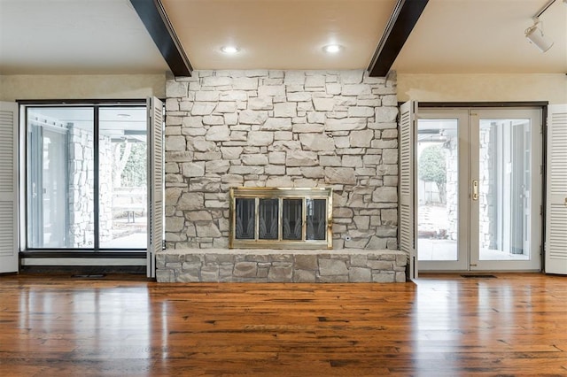 unfurnished living room with beamed ceiling, wood-type flooring, and a fireplace