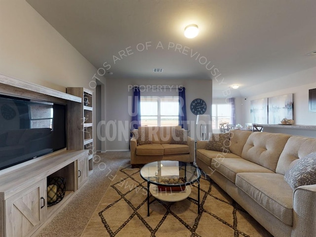 carpeted living room featuring lofted ceiling