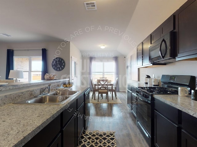 kitchen featuring sink, a wealth of natural light, vaulted ceiling, and black appliances