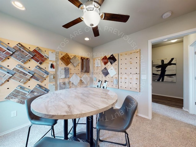 carpeted dining space with ceiling fan