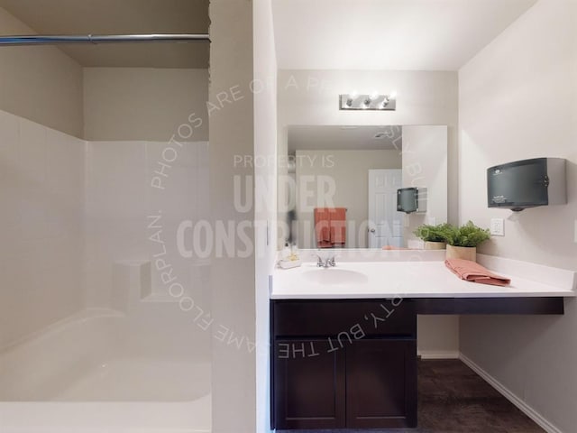 bathroom featuring vanity, wood-type flooring, and a shower