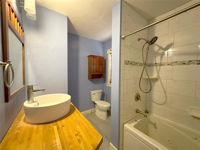 full bathroom featuring tiled shower / bath, sink, and toilet