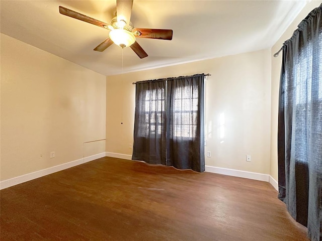 spare room featuring dark wood-type flooring and ceiling fan