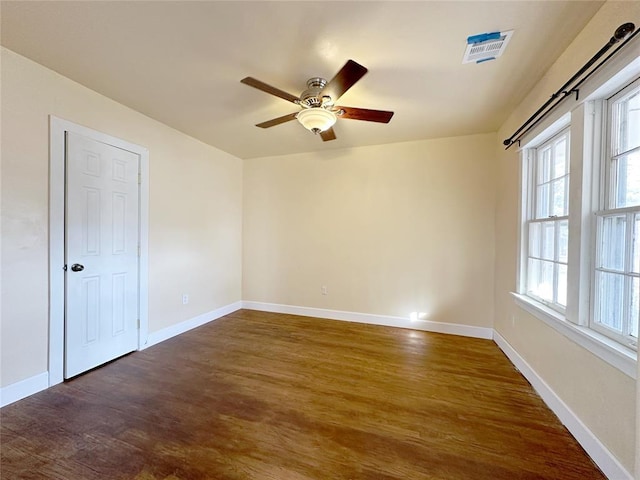 spare room with dark wood-type flooring and ceiling fan