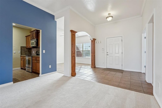 carpeted entryway featuring ornamental molding and ornate columns