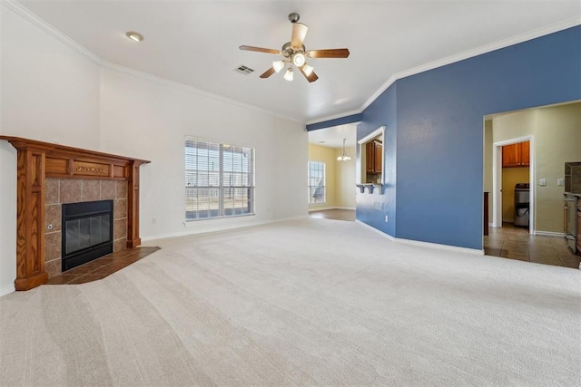 unfurnished living room featuring ceiling fan, carpet flooring, crown molding, and a fireplace