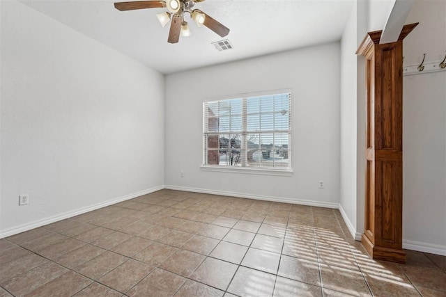 tiled spare room with ceiling fan