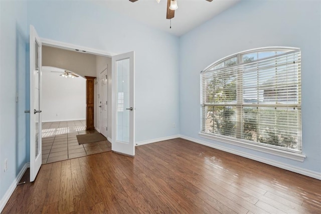 empty room featuring dark wood-type flooring, french doors, and ceiling fan