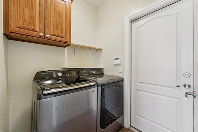 laundry room featuring cabinets and washing machine and clothes dryer