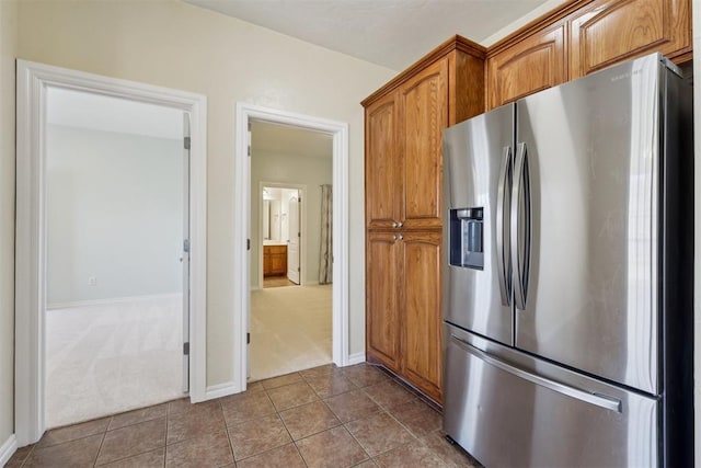 kitchen featuring carpet floors and stainless steel fridge