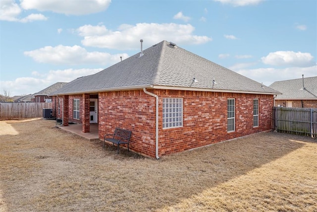 back of property with a yard, central AC unit, and a patio area