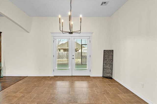 unfurnished dining area with french doors and a notable chandelier