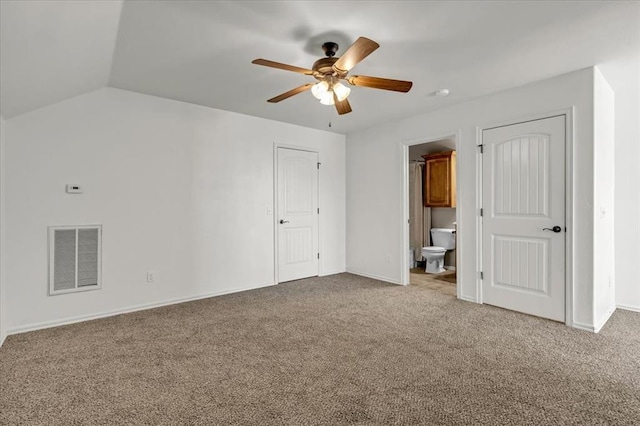 unfurnished bedroom featuring vaulted ceiling, ceiling fan, connected bathroom, and carpet floors