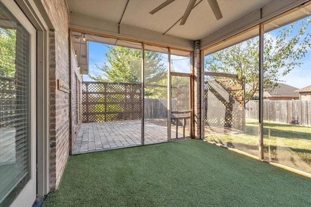 unfurnished sunroom featuring ceiling fan