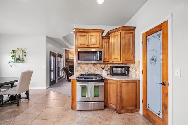 kitchen featuring tasteful backsplash, light tile patterned floors, and appliances with stainless steel finishes