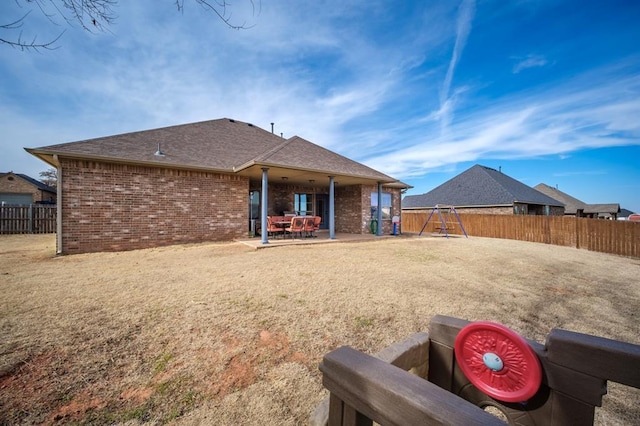 rear view of property with a patio and a playground