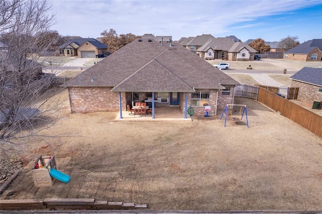 back of house with a patio area and a playground