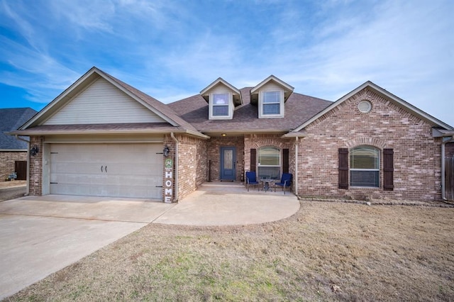 view of front of home with a garage, a patio area, and a front yard