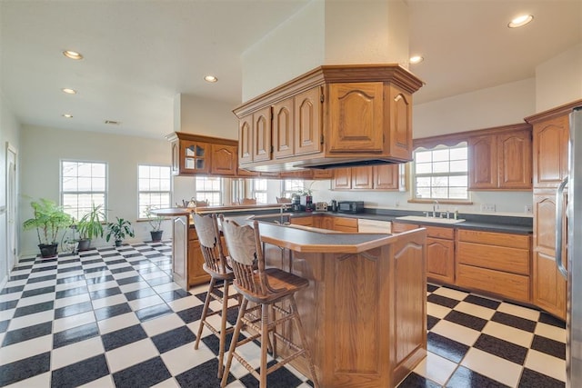 414315 E 1080th Rd, Checotah, OK 74426 - kitchen with light floors, a breakfast bar area, dark countertops, recessed lighting, and brown cabinetry