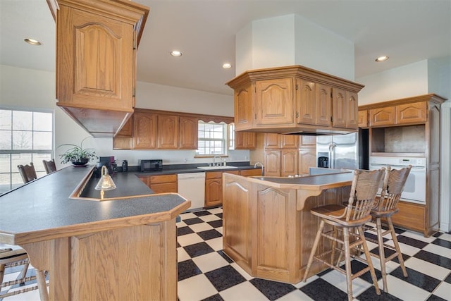 414315 E 1080th Rd, Checotah, OK 74426 - kitchen with white appliances, light floors, a peninsula, a kitchen bar, and recessed lighting