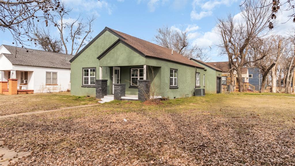 view of front of home featuring cooling unit and a front lawn