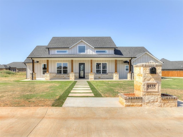 view of front of home featuring a stone fireplace and a front lawn