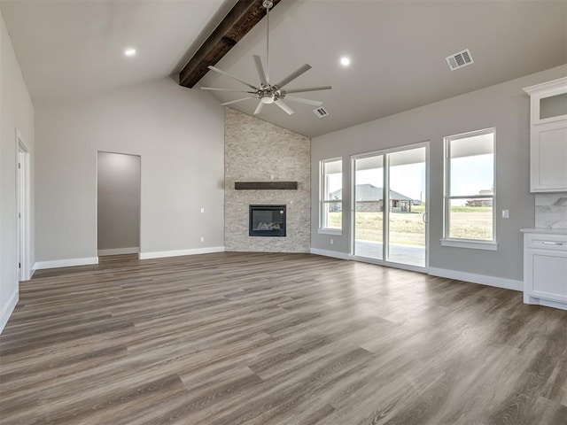 unfurnished living room with beamed ceiling, ceiling fan, hardwood / wood-style flooring, and a fireplace