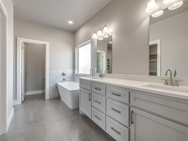 bathroom featuring vanity, a bathing tub, tile walls, and tile patterned floors