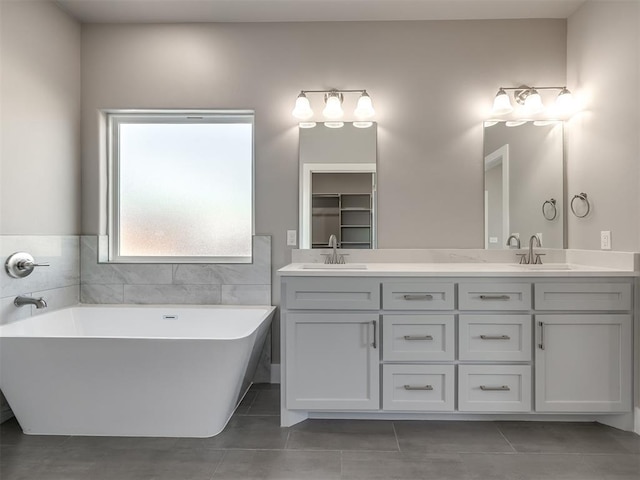 bathroom with vanity, tile patterned flooring, and a tub