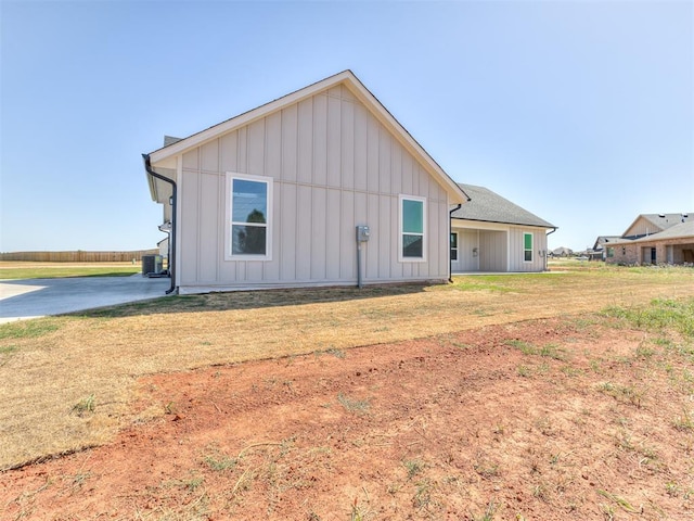 rear view of property with a yard and central AC