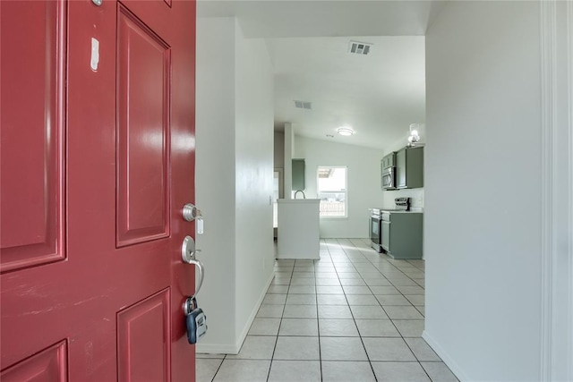 tiled entrance foyer featuring vaulted ceiling