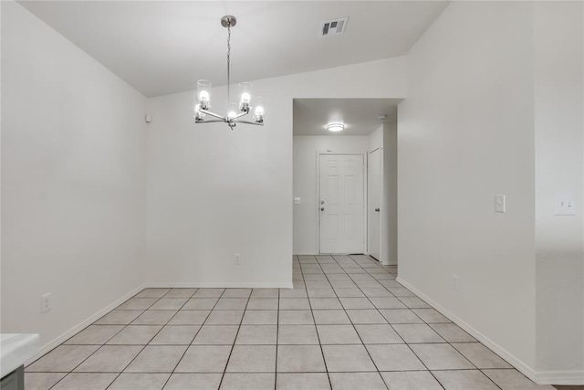 spare room featuring light tile patterned floors, a notable chandelier, and vaulted ceiling