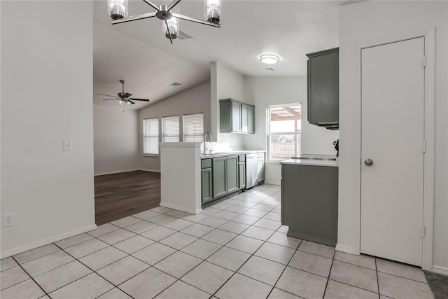 kitchen with light tile patterned floors, a wealth of natural light, dishwasher, and vaulted ceiling