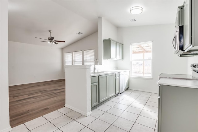 kitchen with light tile patterned floors, gray cabinets, sink, and stove