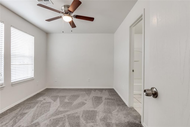 unfurnished room with light colored carpet and ceiling fan