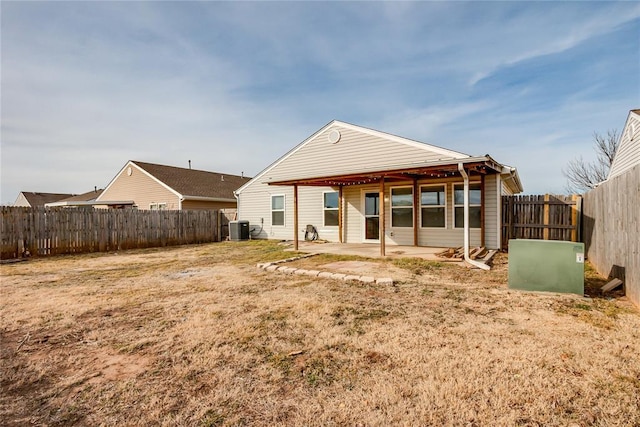 back of property with a patio, a yard, and central AC