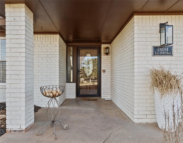 doorway to property with brick siding