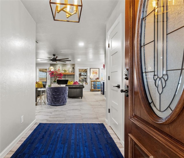 entryway with ceiling fan and baseboards