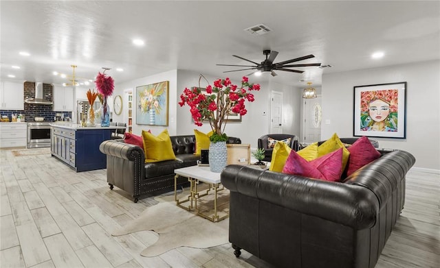 living room with a ceiling fan, light wood-type flooring, visible vents, and recessed lighting