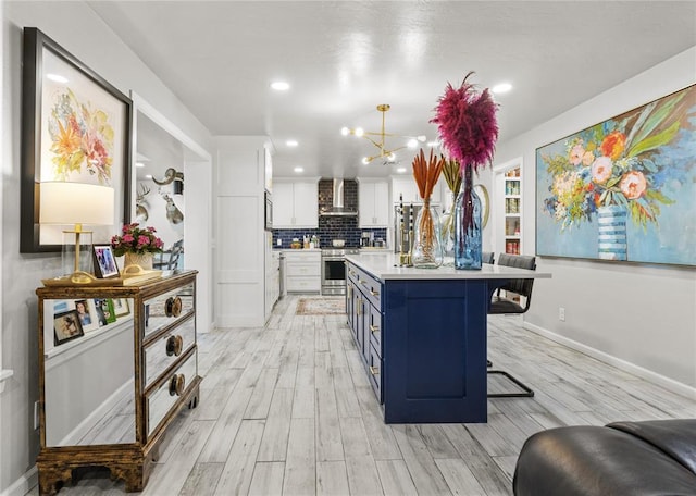 kitchen featuring a breakfast bar area, decorative light fixtures, light countertops, stainless steel stove, and white cabinetry