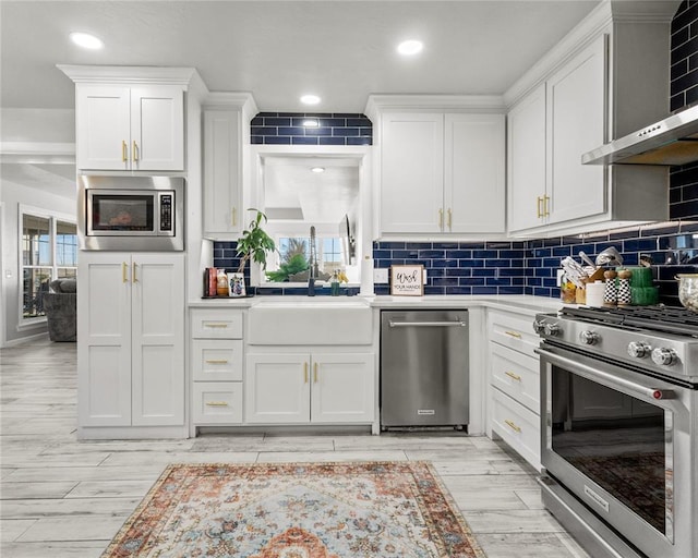 kitchen featuring white cabinets, stainless steel appliances, a sink, and light countertops