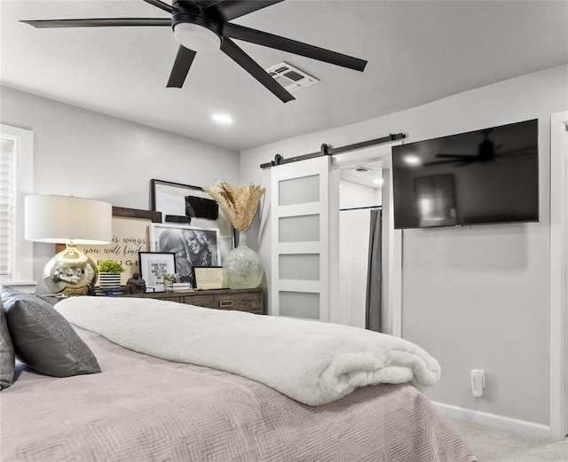 bedroom with carpet floors, visible vents, a barn door, a ceiling fan, and baseboards