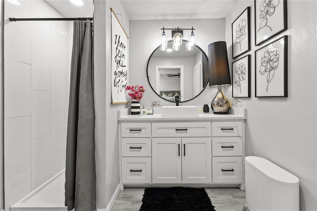 bathroom with a shower stall, vanity, and wood finished floors