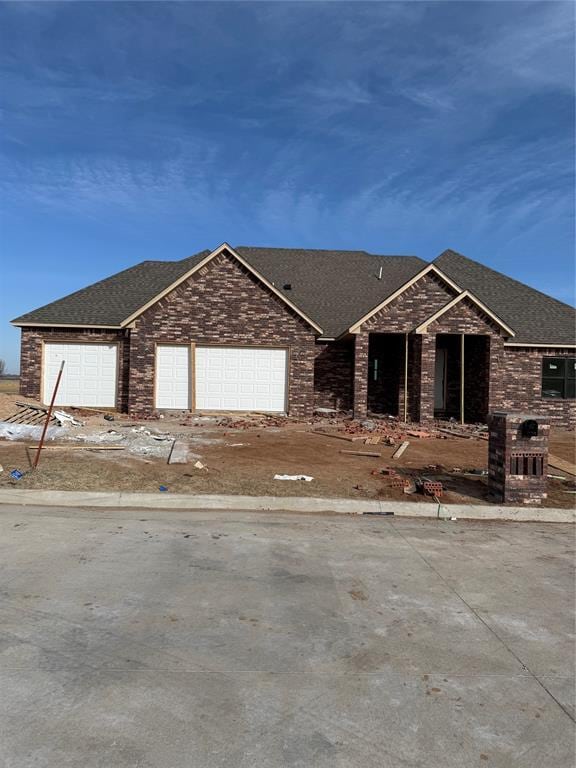 view of front of home featuring an attached garage and roof with shingles