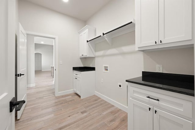 4341 Courtlyn Ave, Tuttle, OK 73089 - laundry area featuring washer hookup, cabinet space, light wood-style flooring, arched walkways, and hookup for an electric dryer