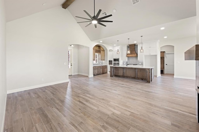 4341 Courtlyn Ave, Tuttle, OK 73089 - unfurnished living room with ceiling fan, recessed lighting, beam ceiling, high vaulted ceiling, and arched walkways