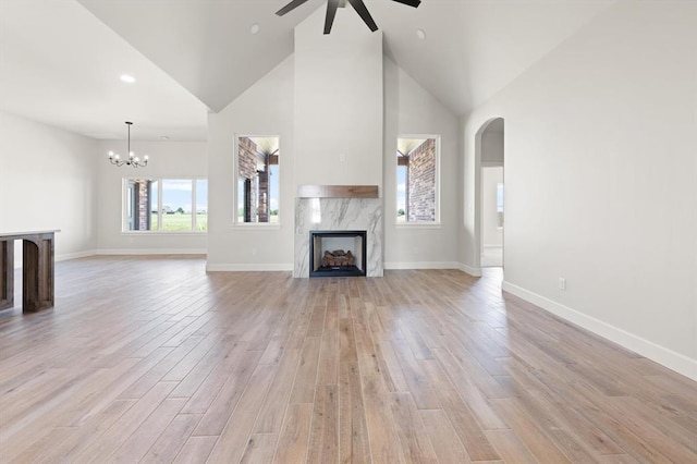 4341 Courtlyn Ave, Tuttle, OK 73089 - unfurnished living room featuring a ceiling fan, a premium fireplace, high vaulted ceiling, light wood finished floors, and arched walkways